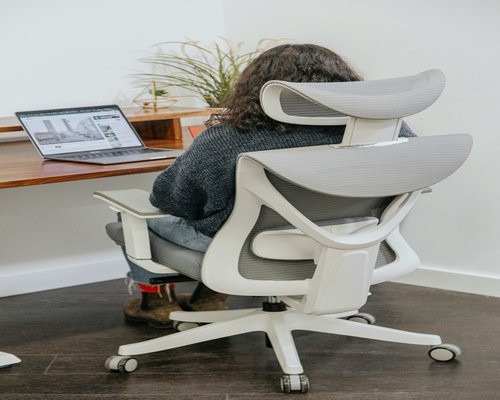 man typing on laptop in an ergonomic office chair